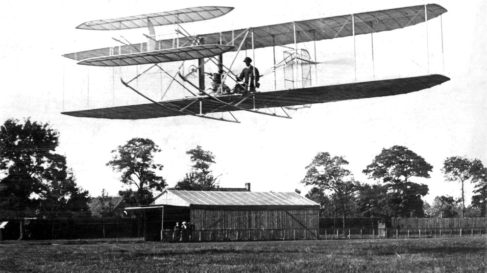 Wilbur Wright bei einem Flug bei Paris 1908. Die Brüder Orville und Wilbur Wright verband der gemeinsame Traum vom Fliegen. Anfang des 20. Jahrhunderts versuchten sie ihn wahr zu machen - und es gelang! Wir erklären euch mehr über die beiden Pioniere des Motorflugs.  | Bild: picture-alliance / dpa | dpa
