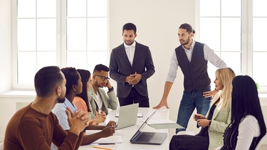 Kollegen sind um einen Tisch versammelt und arbeiten im Team. Teamfähigkeit ist eine der wichtigsten Eigenschaften, die Arbeitgeber an ihren Mitarbeitern schätzen. | Bild: colourbox.de