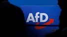 ARCHIV - 28.07.2023, Sachsen-Anhalt, Magdeburg: Delegierte gehen vor dem Parteilogo bei dem AfD-Bundesparteitag in Magdeburg. (zu dpa: «AfD in Sachsen wählt Liste für Bundestagswahl») Foto: Carsten Koall/dpa +++ dpa-Bildfunk +++ | Bild: dpa-Bildfunk/Carsten Koall