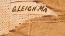 Stoffreste von Mallorys Unterhemd mit Monogramm. Welche Kleidung trug 1924 der am Mount Everest verschollene Bergsteiger George Mallory? Hier erfahrt ihr mehr über die Ausrüstung von Mallory.  | Bild: Rick Reanier/Archiv Jochen Hemmleb, Bozen