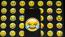 Ein Tränen-lach-Smiley vor einem Hintergrund aus anderen Emojis. Der Smiley ist aus unserer digitalen Kommunikation nicht wegzudenken, ob als Grafik oder als Tastenkürzel :-) Was Emojis bedeuten und wie sie die Sprache verändern. | Bild: picture alliance / AA | Aytavß vúnal