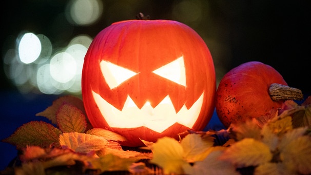 Geschnitzter Kürbis mit Kerze an Halloween. Am 31. Oktober ist Halloween. Woher stammt der Brauch, wie ist er nach Deutschland gekommen und warum schnitzen und beleuchten wir Kürbisse? | Bild: picture-alliance/dpa