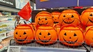 Kürbislaternen aus Plastik, die als Behälter für Süßigkeiten dienen, in einem deutschen Supermarkt in Shanghai. Geschnitze Kürbisse sind ein Symbol für Halloween. Am 31. Oktober ist Halloween. Woher stammt der Brauch, wie ist er nach Deutschland gekommen und warum schnitzen und beleuchten wir Kürbisse? | Bild: picture-alliance/dpa