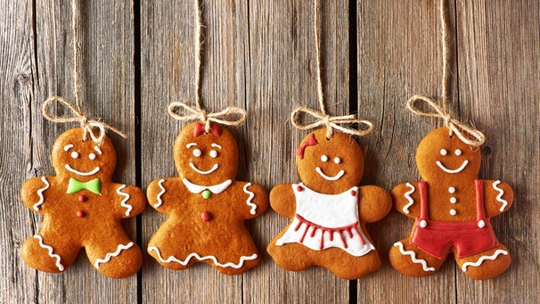 Lebkuchenmännchen auf einem Holzuntergrund. Um das klassisch-köstliche Weihnachtsgebäck ranken sich viele bunte Geschichten. Eine der glaubwürdigsten: Der Lebkuchen soll angeblich aus Not entstanden sein, weil Mehl fehlte.  | Bild: stock.adobe.com/haveseen