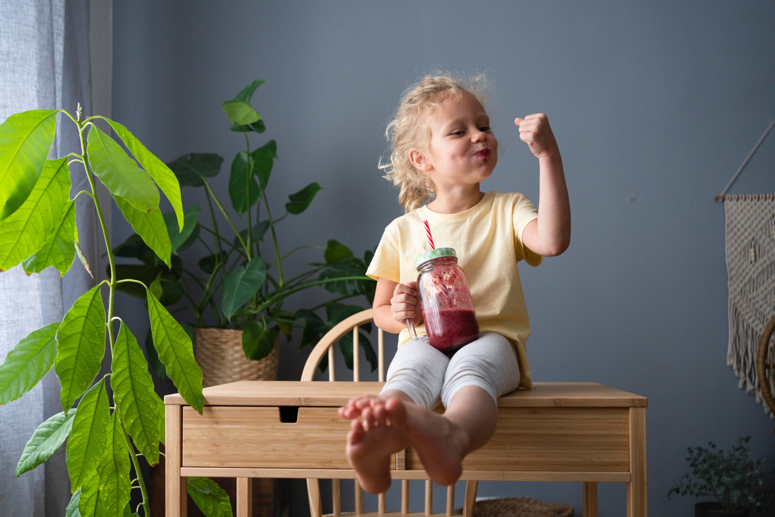 Ein Mädchen trinkt gesunden Frucht-Smoothie und lässt zu Hause die Muskeln spielen. Das Immunsystem schützt den Körper vor Krankheitserregern. Wir erklären, wie du deine Körperabwehr durch vitaminreiche Ernährung stärken kannst.
| Bild: picture alliance / Westend61 | Svetlana Karner