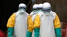 ARCHIV - 16.07.2019, Kongo, Beni: Helfer in spezieller Schutzkleidung kommen zur Arbeit in ein Ebola-Behandlungszentrum. Der zentralafrikanische Kongo ist offiziell frei von der gefährlichen Krankheit Ebola.  | Bild: dpa-Bildfunk/Jerome Delay