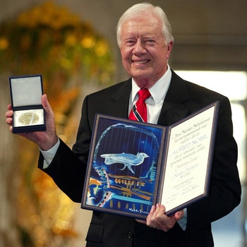 Der Friedensnobelpreisträger und frühere US-Präsident Jimmy Carter mit Urkunde und Medaille des Nobelpreises 2002. Nachdem Alfred Nobel 1896 gestorben war, dauerte es noch vier Jahre, bis die Nobelstiftung eingerichtet war. 1901 wurde erstmals der Nobelpreis verliehen. | Bild: picture-alliance/dpa