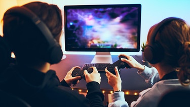 Ein Mädchen und ein Junge spielen ein Computerspiel. Computerspiele machen vielen Kindern Spaß. Zuviel Gaming kann jedoch zur Abhängigkeit führen. Was sind die Anzeichen einer Sucht? Wann solltet ihr einschreiten? | Bild: picture alliance/Zoonar/Przemek Klos