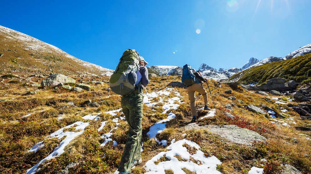 Ein Pärchen wandert in den Bergen im Herbst. Ob beim Sport, in der Beziehung oder im Beruf, Durchhaltevermögen ist überall gefragt. Doch ab wann wird durchhalten schädlich? Darauf solltet ihr achten. | Bild: colourbox.com, Galyna Andrushko