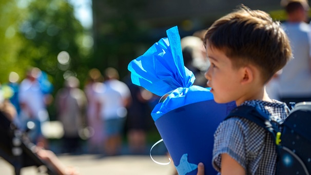 Ein Junge trägt zur Einschulung eine blaue Schultüte. Was ist wichtig für einen erfolgreichen Schulanfang? Tipps, die eurem Kind den Start in der Grundschule erleichtern. | Bild: picture alliance/Kirchner-Media/Christopher Neundorf