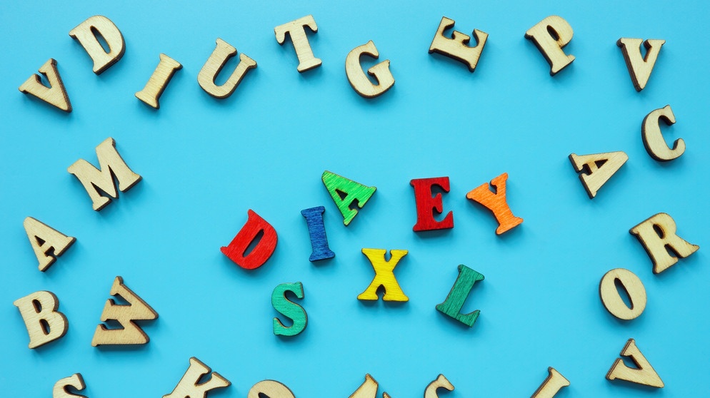 Bunte Buchstaben, in der Mitte liegt das englische Wort 'Dyslexia' für Dyslexie. Wenn Buchstaben keinen Sinn ergeben, spricht man von Legasthenie: Vier bis sieben Prozent der Kinder sind betroffen. Das Gehirn arbeitet in bestimmten Bereichen anders. Hört hier, wie spezielle Lernmethoden bei Legasthenie helfen können.  | Bild: colourbox.com