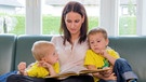 Eine Mutter liest Ihren Kindern ein Märchen aus einem Buch vor. | Bild: stock.adobe.com/Gina Sanders