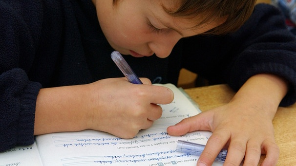 schreibender Schüler im Deutschunterricht. Immer wieder werden neue Studien zur Lese- und Rechtschreibschwäche veröffentlicht. Doch noch immer wissen die Forscher nicht, warum manche Menschen ein Leben lang Schwierigkeiten mit dem Lesen und Schreiben haben. | Bild: picture-alliance/dpa