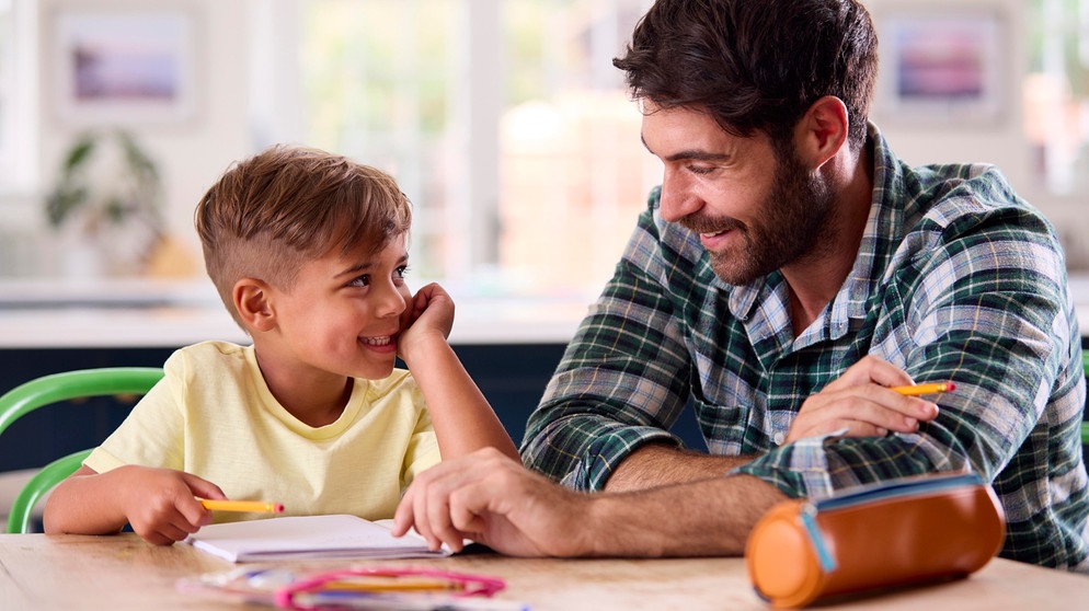 Vater hilft Sohn bei den Hausaufgaben. Was ist wichtig für einen erfolgreichen Schulanfang? Tipps, die eurem Kind den Start in der Grundschule erleichtern. | Bild: picture alliance / Shotshop | Monkey Business 2