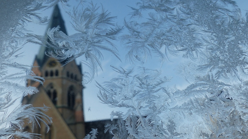 Eisblumen in Sankt Ottilien. Ihr fragt euch, wie und warum sich im Winter Eiskristalle am Fenster bilden? Wir erklären euch, wann Eiskristalle und Eisblumen entstehen und warum Eiskristalle sechseckig sind. Außerdem erfahrt ihr, was der Unterschied zwischen Eiskristallen und einer Schneeflocke ist und wie viele Eiskristalle in einer Schneeflocke sind. | Bild: Wunibald Wörle