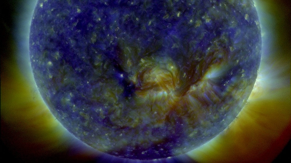 Eine aktuelle Aufnahme unserer Sonne in drei verschiedenen - für das menschliche Auge unsichtbaren - ultravioletten Wellenlängen, zu einer Aufnahme zusammengesetzt und für uns sichtbar koloriert. Am äußeren Rand sind kleinere Flares zu sehen, auf der Oberfläche das heiße Plasma. | Bild: Courtesy of NASA/SDO and the AIA, EVE, and HMI science teams.