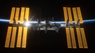 Die vier Sonnensegel der ISS werden von der aufgehenden Sonne angestrahlt und funkeln. | Bild: NASA / ESA