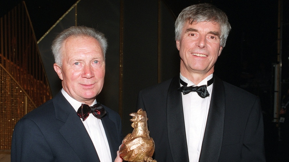 Ulf Merbold (rechts) überreicht Sigmund Jähn (links) 1999 die "Goldene Henne". Mit dem ostdeutschen Medienpreis wird der erste Deutsche im All von seinem Freund für sein Lebenswerk ausgezeichnet. Der Kosmonaut der DDR verstarb 2019 mit 82 Jahren. | Bild: picture-alliance/dpa