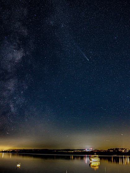 Der Komet C/2023 A3 Tsuchinshan-ATLAS am 28. Oktober 2024 über dem Starnberger See, fotografiert von Marco Sproviero. Aber er hat nicht nur den Kometen fotografiert: "Schön zu sehen ist links davon die Milchstraße und schräg links über dem Kometen die beiden offenen Sternhaufen IC4756 (Graffs Haufen) und NGC 6633 (Tweedledum-Haufen)." | Bild: Marco Sproviero