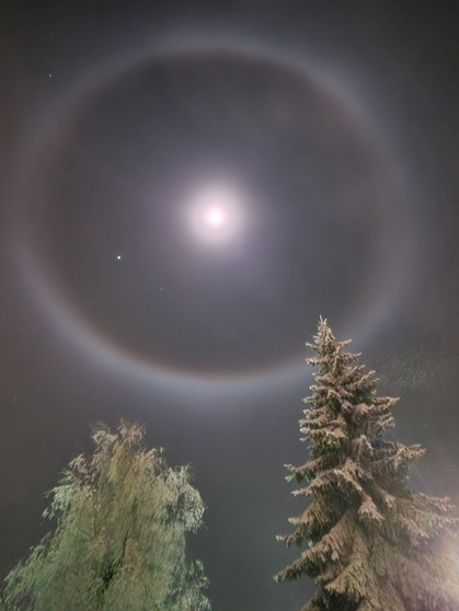 Eine Mondhalo über mit Raureif bedeckten Bäumen, fotografiert am 13. Dezember 2024 über Oberwiesenthal von Matthias Große. | Bild: Matthias Große