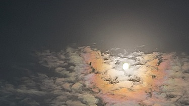 Mond mit Mondhof, teilweise hinter Wolken und in Regenbogenfarben. Aufgenommen von Elisabetz Lutz mit einem  Mobiltelefon. | Bild: Elisabetz Lutz