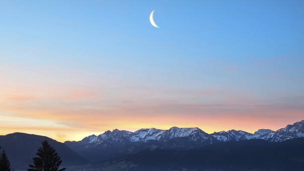 abnehmende Mondsichel morgens kurz vor Neumond über dem Ammergebirge (und dem Forggensee) im November 2015 | Bild: imago/blickwinkel