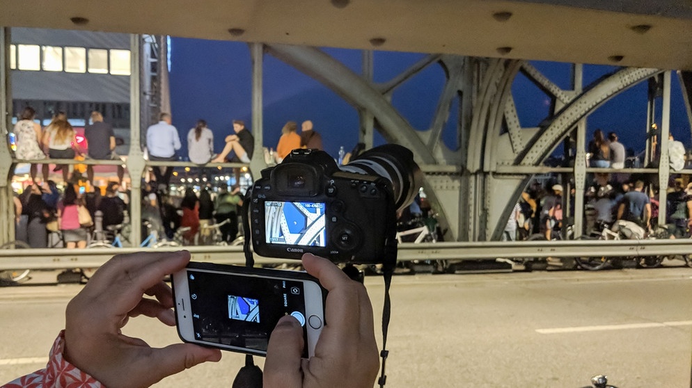 Menschen stehen auf der Münchner Hackerbrücke und beobachtendie totalen Mondfinsternis am 27. Juli 2018, aufgenommen von Folke Ashberg | Bild: Folke Ashberg