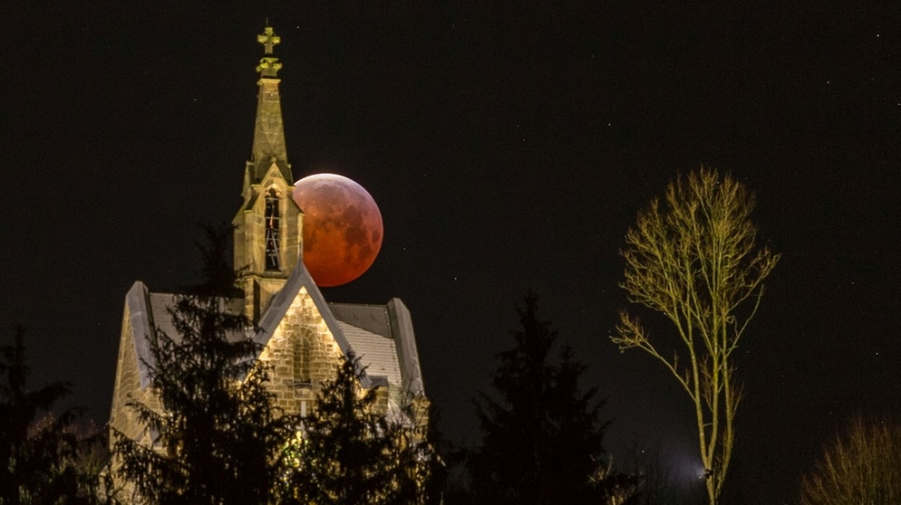 Der Blutmond bei totaler Mondfinsternis am 21. Januar 2019, halb versteckt hinter einer Kirche in Arnsberg. Fotografiert von Britta Lieder | Bild: Britta Lieder