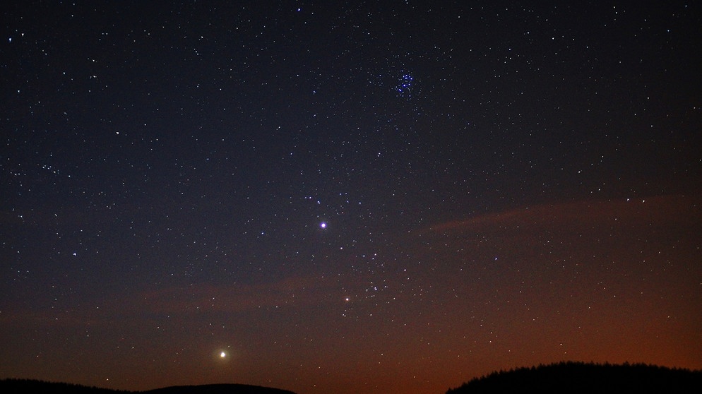 Die beiden hellen Planeten Venus (dicht am Horizont) und Jupiter (darüber) unter dem Offenen Sternhaufen der Plejaden (Siebengestirn) im Sternbild Stier frühmorgens im Sommer. Aufgenommen mit Blick nach Osten am 24.07.12 gegen 03:00 Uhr.  | Bild: Horst Ulbricht