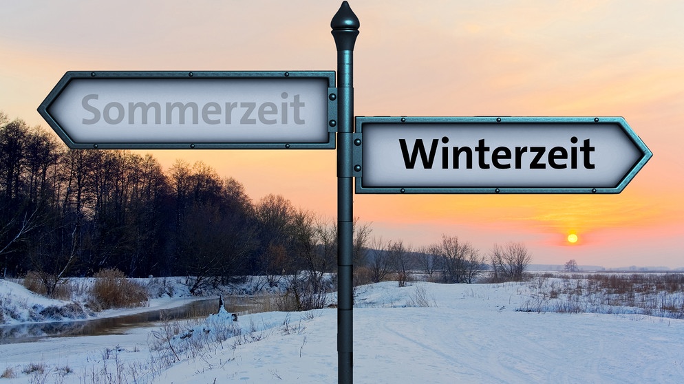 Zwei Schilder in entgegengesetzte Richtungen: Sommerzeit und Winterzeit. Sommerzeit  ist ausgegraut. Hat die Zeitumstellung gesundheitliche Folgen? Und warum wird überhaupt an der Uhr gedreht? | Bild: colourbox.com